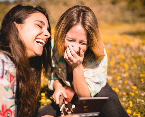 Two young women laughing about Colombian Spanish