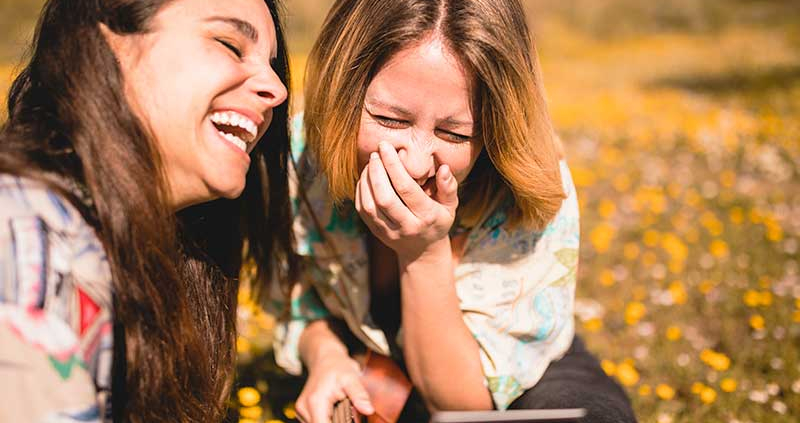 Two young women laughing about Colombian Spanish