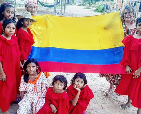 Wayuu culture Colombia. A group of Wayuu people holding the Colombian flag.