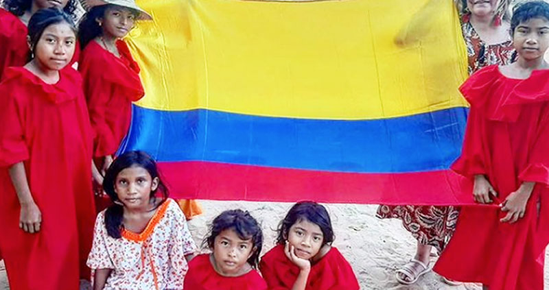 Wayuu culture Colombia. A group of Wayuu people holding the Colombian flag.