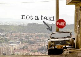 A Car in Bogotá, Colombia, the photo has the text "not a taxi" The Best Way to Navigate Bogotá's Public Transport while learning Spanish.