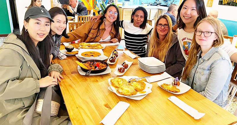 Group of students in a restaurant. What is the cost of learning Spanish in Bogota in 2023?