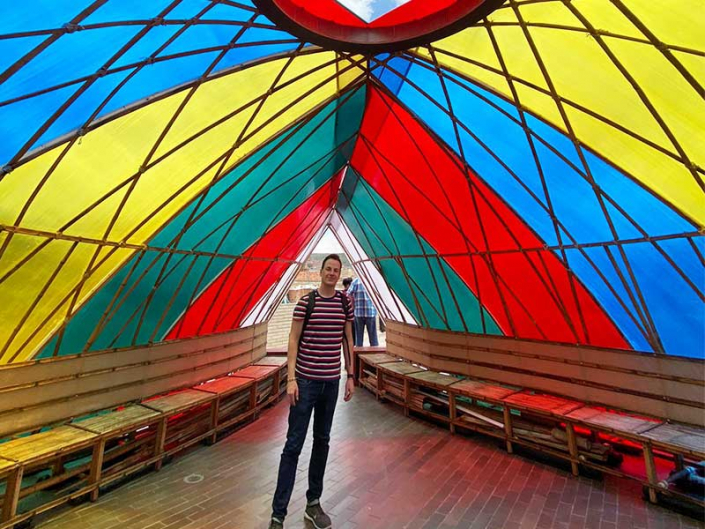 Student in Bogota in a colorful art installation