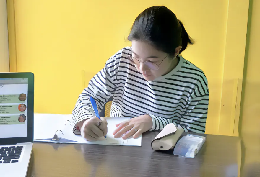 Student on a desk writing in the classroom learning Spanish